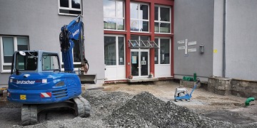 Bagger steht vor dem Eingangsbereich