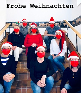 Frohe Weihnachten - Schulpersonal auf der Treppe sitzend